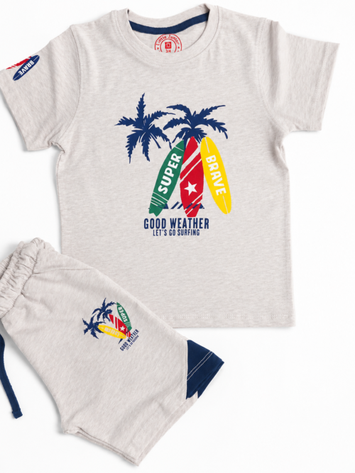Cute little boy wearing oatmeal color surf print t-shirt with matching shorts in a grey and white studio background, soft cotton summer outfit for kids